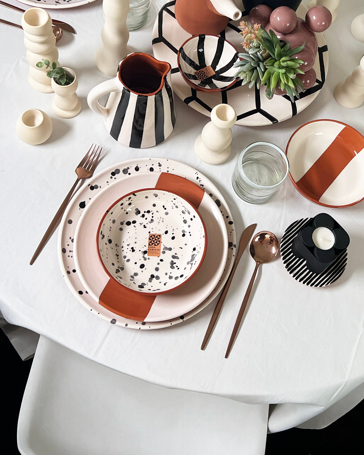 A table setting with the rectangle salad plate and the splattered dinner plate and bowls.