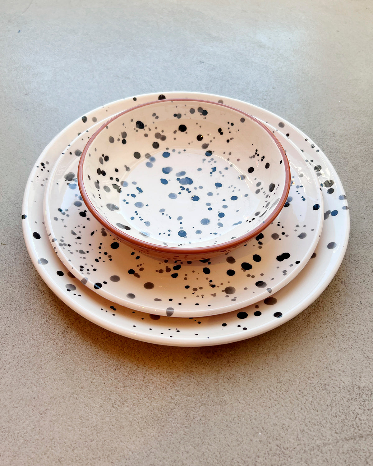 Splattered dinner plate, salad plate, and bowl together. 